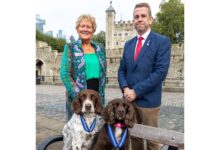 PDSA Director General, Jan McLoughlin, and Stuart Phillips (handler), with Yoyo (right) and Scamp (left)